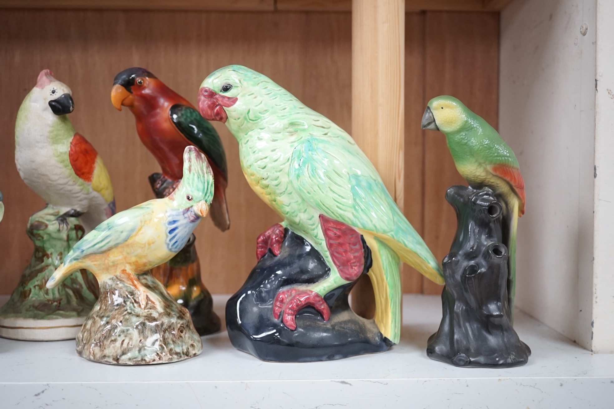 A group of twelve ceramic parrots including one by S Hancock & Sons, largest 24cm high. Condition - mostly good